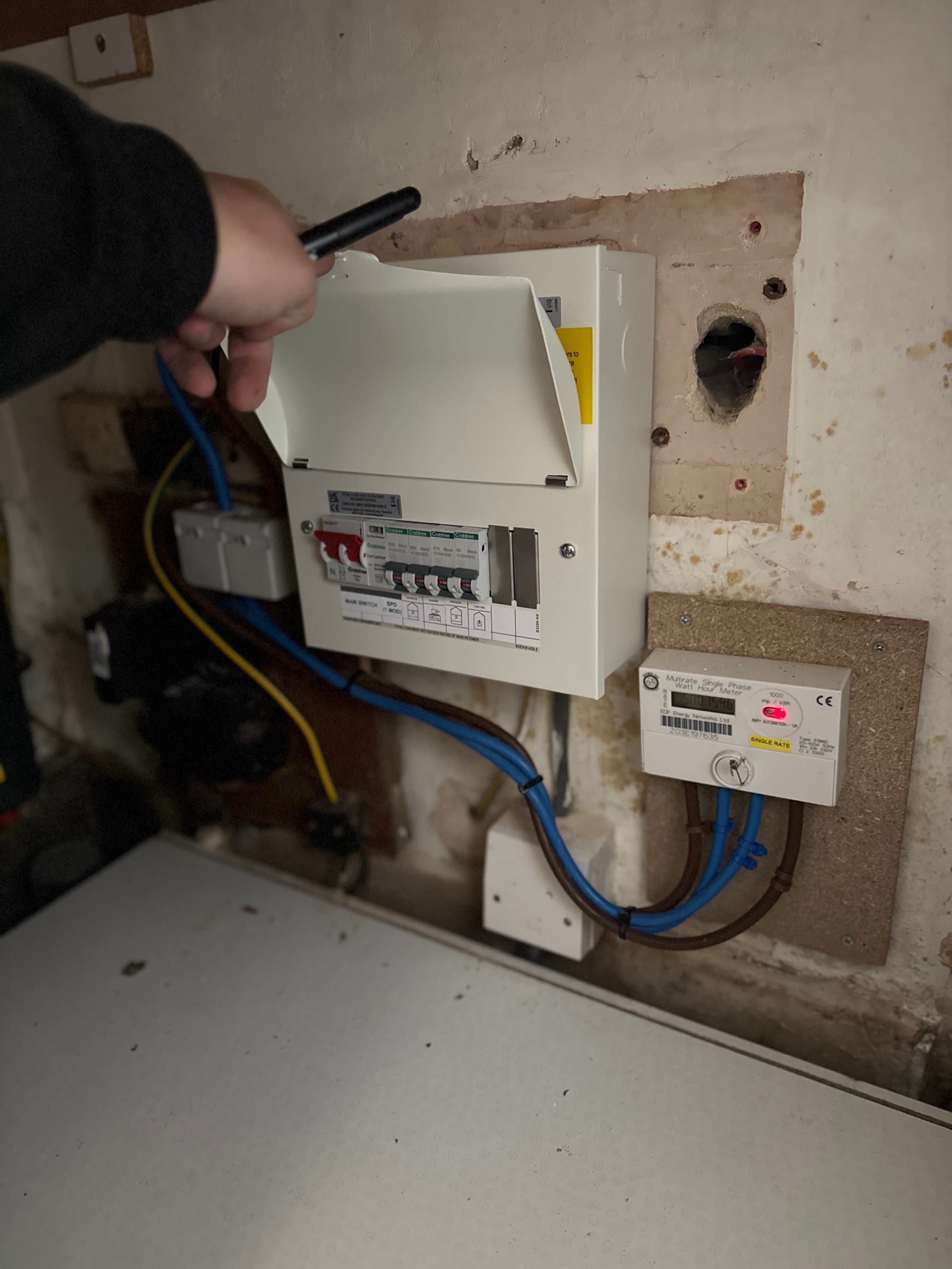 Open consumer unit being checked during electrical testing